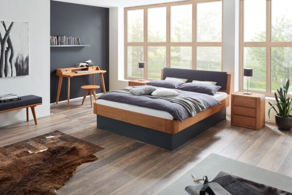 massives Holzbett mit Stauraum aus der Hasena Oak Line in einem hellen, holzlastigen Raum