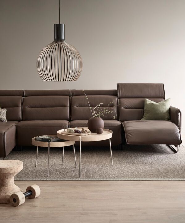 Stressless-Sofa Emily in der Farbe chestnut mit passendem Sessel in einem beige gehaltenen Raum