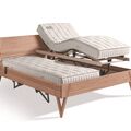 Ein verstellbares Bettgestell mit komfortabler Matratze und modernem Holzdesign, ideal für entspanntes Schlafen.