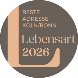 Ein rundes Logo mit dem Text "Beste Adresse Köln/Bonn" und "Lebensart 2026" in eleganten Schriftarten.