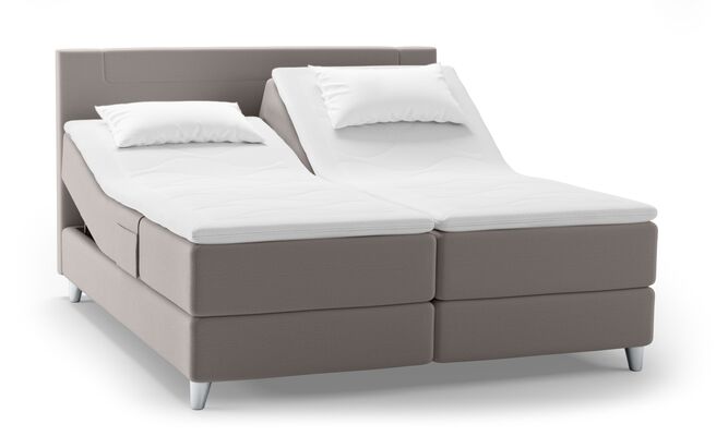 Ein verstellbares Svane-Bett in Eisgrau mit zwei Matratzen und Kopfkissen, ideal für individuellen Schlafkomfort.