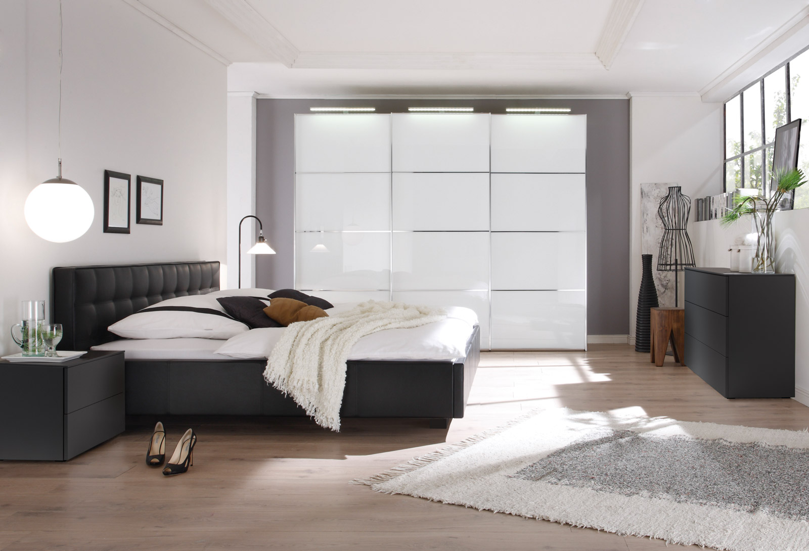 Ein modernes Schlafzimmer mit einem gemütlichen Bett, eleganten Möbeln und einem hellen, einladenden Ambiente.