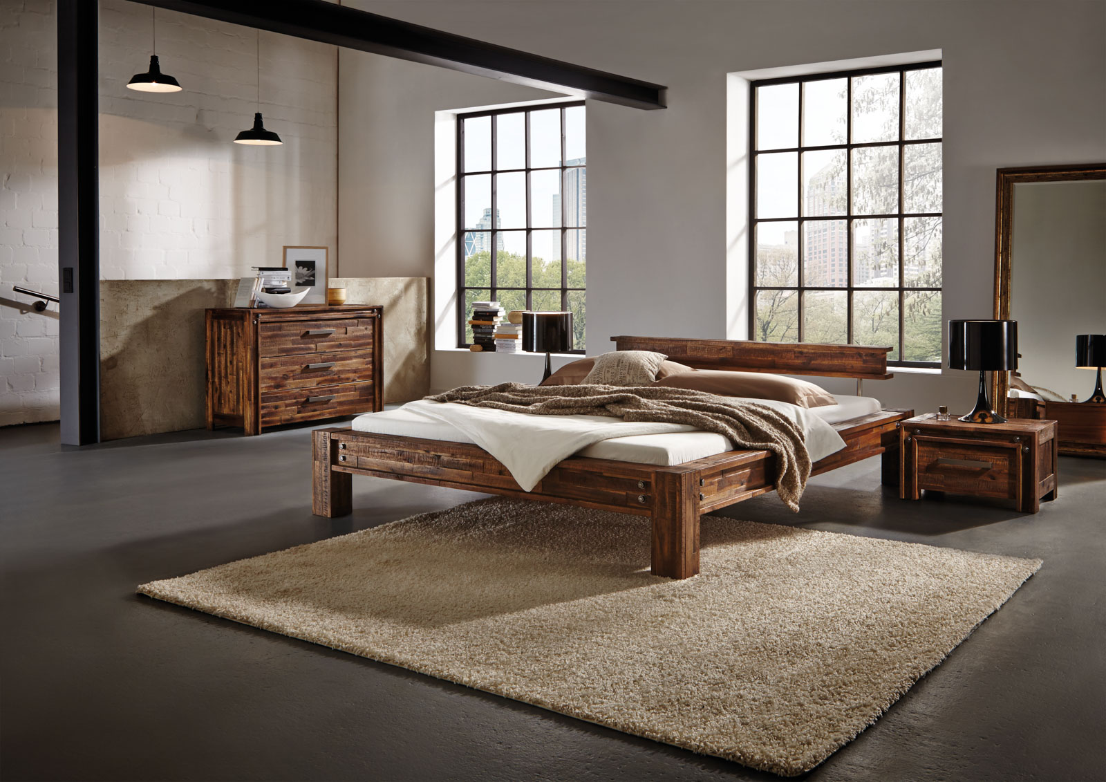Mittelbraunes Holzbett mit markanter Maserung in einem Raum mit Industrial-Style-Elementen.