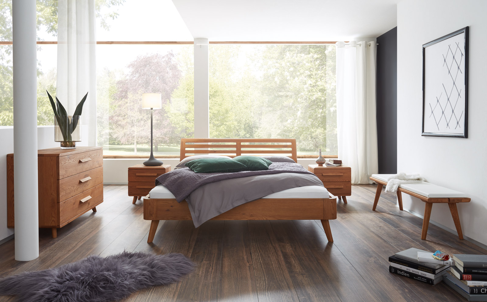 Mittelbraunes Holzbett mit Nachttischen und Kommode vor einem Fenster