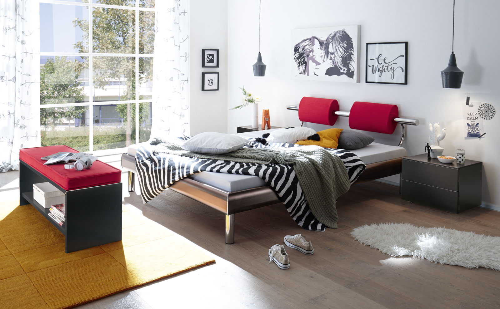 Hasena-Bett der Softline-Reihe mit rotem Elementen am Kopfteil und einer Decke mit Zebramuster.