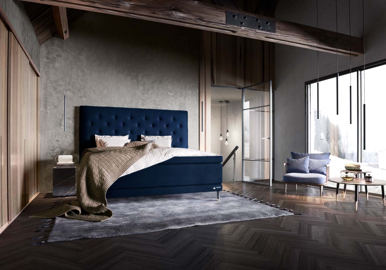 Dunkelblaues Svane-Zincere-Bett in einem stilvoll eingerichteten Schlafzimmer mit dunklem Boden und grauen Wänden