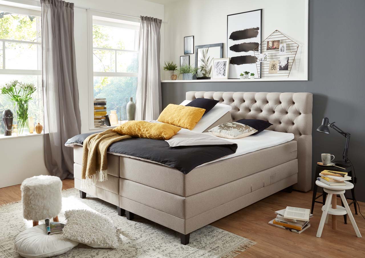 Ein stilvolles Schlafzimmer mit einem komfortablen Bett, dekorativen Kissen und einem hellen, einladenden Ambiente.